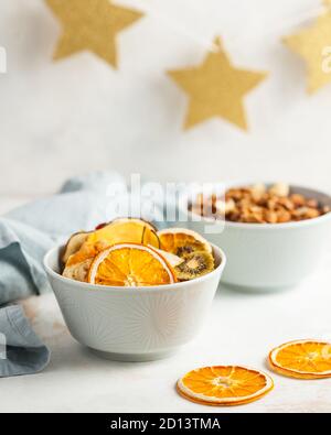 Getrocknete Früchte Orange, Banane, Kiwi, Birne, Erdbeeren Nahaufnahme auf hellem Hintergrund mit blauer Textilserviette Stockfoto