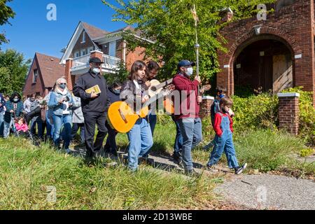 Detroit, Michigan - Missionare mit dem Neokatechumenalen Weg führen eine Prozession vorbei an einem beenterten Haus auf der Ostseite von Detroit, gefolgt von einem ou Stockfoto