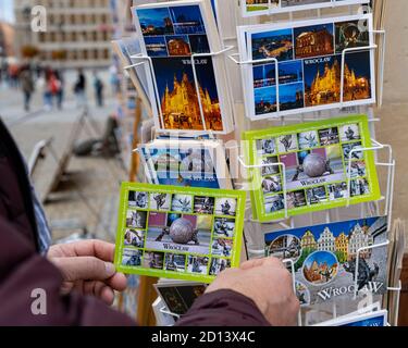 BRESLAU / POLEN - 26. SEPTEMBER 2019: Tourist wählt eine Postkarte in einem Souvenirladen auf dem zentralen Platz in Breslau Stockfoto