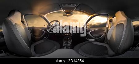 Elektrischer Kleinwagen Innenansicht als 360 Grad Panorama. Die Rücksitze sind nach unten geklappt, um viel Stauraum im hinteren Bereich zu schaffen. Wolkiger Himmel an der Sonne Stockfoto