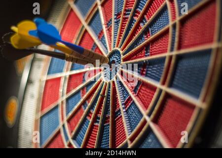 Nahaufnahme einer Dartscheibe mit drei Darts in der Zentrieren Stockfoto