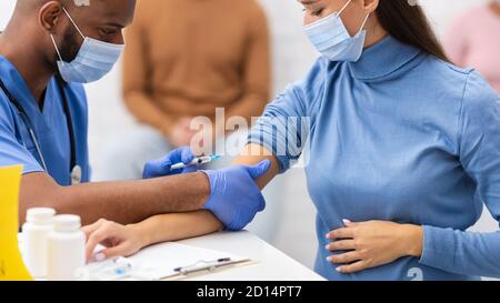 Schwangere Frau, Die Covid-19-Impfstoffinjektion Im Klinikraum Erhält Stockfoto
