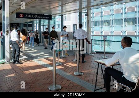 Hongkong, China. Oktober 2020. Sicherheitskräfte mit Gesichtsmasken kontrollieren die Temperatur der Studenten beim Betreten des Universitätsgeländes in Hongkong. Hongkonger Schulen treffen zusätzliche Vorsichtsmaßnahmen gegen den Ausbruch des Coronavirus, wie das Tragen von Masken, Temperaturkontrollen und die Desinfektion der Hände. Kredit: SOPA Images Limited/Alamy Live Nachrichten Stockfoto