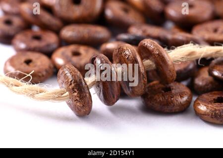 Holzperlen mit Naturjute String Twine Rope auf weißem Hintergrund. Nahaufnahme, Makro. Stockfoto