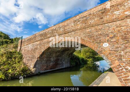 Traditionelle Backsteinstraße Brücke über den Fluss Dun, Kennet und Avon Canal Bruce Branch, Great Bedwyn, einem ländlichen Dorf in Wiltshire, Südengland Stockfoto