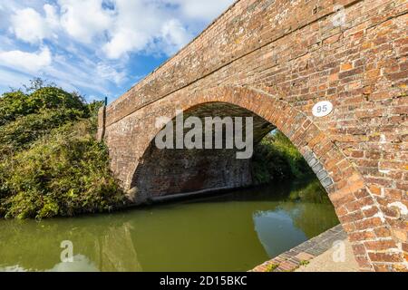 Traditionelle Backsteinstraße Brücke über den Fluss Dun, Kennet und Avon Canal Bruce Branch, Great Bedwyn, einem ländlichen Dorf in Wiltshire, Südengland Stockfoto