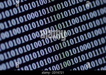 Binäre Ziffernfolge, die auf einem Computerbildschirm angezeigt wird. Das Muster von 0s und 1s verschlüsselt Informationen in Netzwerk- (IT-) und Kommunikationssystemen. Stockfoto