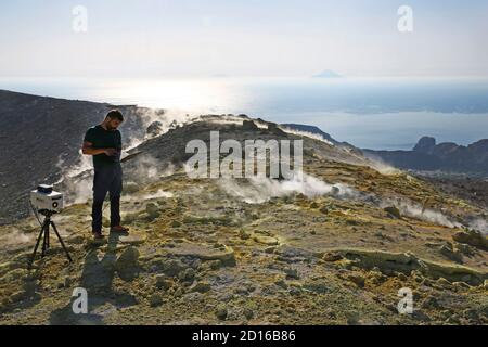 Italien, Sizilien, Äolische Inseln, Vulcano, Vulkanologe, der Messungen vor dem rauchenden und gelben schwefelsüchtigem Krater des aktiven Vol Stockfoto