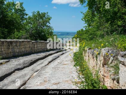 Die altertümliche steinige Straße durch Tschufut-Kale, die mittelalterliche Höhlensiedlung in Krim Stockfoto
