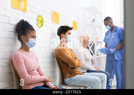 Patienten, Die Auf Die Covid-19-Impfung Warten, Sitzen In Der Warteschlange Im Krankenhaus Stockfoto