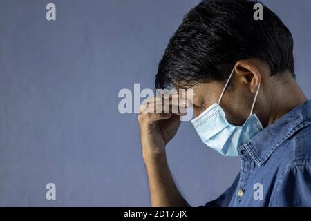 Menschen, Gesundheitsproblem und Stresskonzept - Seitengesicht eines indischen Mannes, der unter Kopfschmerzen mit Nasenmaske leidet Stockfoto