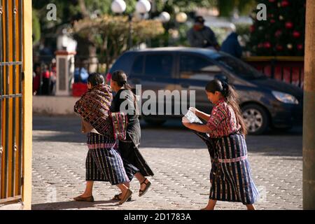 Drei indigene, ethnische Kaqchikel Maya Frauen, die auf dem Stadtplatz in Sololá, Guatemala, spazieren gehen. Stockfoto