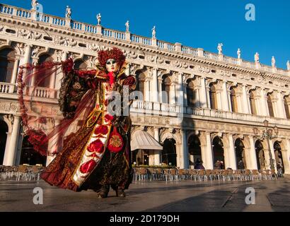 VENEDIG, ITALIEN - FEBRUAR 2016 :EINE rote Maske während des Karnevals in Venedig zeigt ihr schönes Kostüm Stockfoto