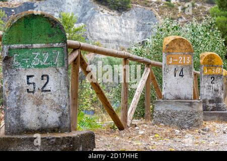 Alte Meilensteine, die auf der Straße Bailen-Motril (N-323) bei der Durchfahrt durch La Cerradura de Pegalajar (Jaen-Spanien) aufgedeckt wurden Stockfoto