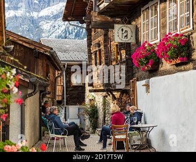 Das Godswärgistubu in Albinen ist ein sehr schönes historisches Walliser Restaurant und bietet saisonale Gerichte aus dem eigenen Garten oder aus dem, was in den Feldern, Wäldern und Wiesen der Region wächst. Geführte Kräuterwanderung durch Albinen im Wallis, Schweiz Stockfoto