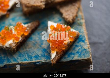 Pazifischer Lachskaviar, gekauft aus einem Supermarkt, serviert auf Roggenbrot mit Frischkäse und garniert mit frischem Dill. Dorset England GB Stockfoto