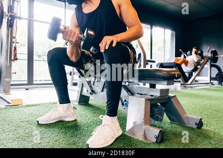 Der junge Mann trägt eine schützende Gesichtsmaske Der Fitnessraum Stockfoto