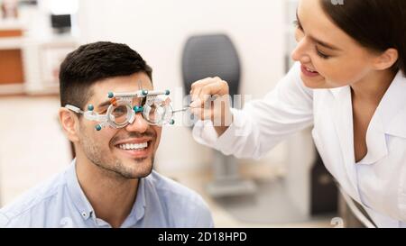Optiker überprüfen die Sehkraft des Patienten mit Studienrahmen Stockfoto