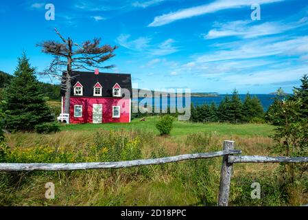 Tors Cove, Neufundland/Kanada - Oktober 2020: Ein kleines rotes historisches Haus mit drei Dachfenstern, zwei Doppelfenstern und einer weißen Tür. Stockfoto