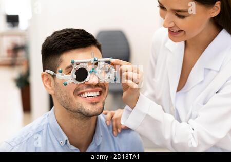 Augenarzt, der die Sehkraft der Patienten mit dem Rahmen der Studie überprüft Stockfoto