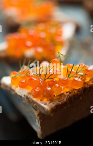 Pazifischer Lachskaviar, gekauft aus einem Supermarkt, serviert auf Roggenbrot mit Frischkäse und garniert mit frischem Dill. Dorset England GB Stockfoto