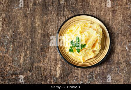 Pürierte Pastinaken mit Kartoffeln und Karotten auf dunklem Holzhintergrund. Köstliche und gesunde vegetarische Lebensmittel, reich an Vitaminen und Mineralstoffen. Obere Aussicht, Stockfoto