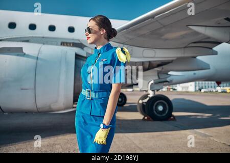 Lächelnd attraktive Stewardess, die sich auf den Flug vorbereitet Stockfoto