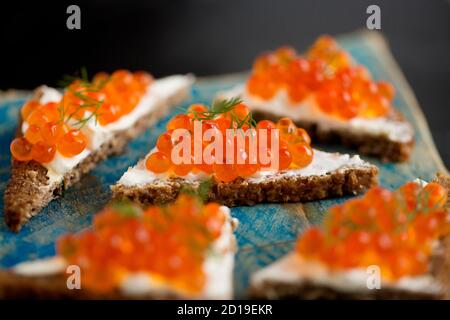 Pazifischer Lachskaviar, gekauft aus einem Supermarkt, serviert auf Roggenbrot mit Frischkäse und garniert mit frischem Dill. Dorset England GB Stockfoto