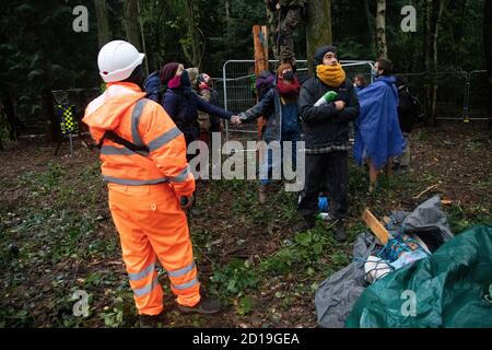 Cubbbington Woods, Warwickshire, Großbritannien. Oktober 2020. In den frühen Morgenstunden des 5. Okt. 2020 ergreifen friedliche HS2-Demonstranten Maßnahmen zum Schutz der Eichen und alten Wälder, die für die Zerstörung in Cubbbington Woods, Warwickshire, Großbritannien, markiert sind. Demonstranten erhalten Zugang zu dem Land, das HS2 erworben hat und Arme um Bäume verbindet, die mit Farbe gekennzeichnet sind Kredit: Denise Laura Baker/Alamy Live News Stockfoto