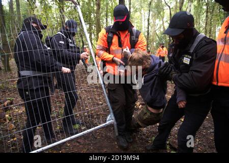 Cubbbington Woods, Warwickshire, Großbritannien. Oktober 2020. In den frühen Morgenstunden des 5. Okt. 2020 ergreifen friedliche HS2-Demonstranten Maßnahmen zum Schutz der Eichen und alten Wälder, die für die Zerstörung in Cubbbington Woods, Warwickshire, Großbritannien, markiert sind. Sie werden mit einer gewaltsamen Räumung durch HS2-Sicherheitskräfte getroffen, vor allem weibliche Demonstranten, die grob behandelt werden Kredit: Denise Laura Baker/Alamy Live News Stockfoto