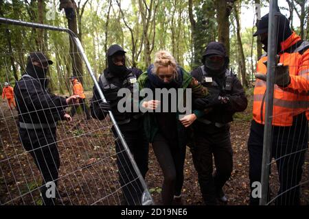 Cubbbington Woods, Warwickshire, Großbritannien. Oktober 2020. In den frühen Morgenstunden des 5. Okt. 2020 ergreifen friedliche HS2-Demonstranten Maßnahmen zum Schutz der Eichen und alten Wälder, die für die Zerstörung in Cubbbington Woods, Warwickshire, Großbritannien, markiert sind. Sie werden mit einer gewaltsamen Räumung durch HS2-Sicherheitskräfte getroffen, vor allem weibliche Demonstranten, die grob behandelt werden Kredit: Denise Laura Baker/Alamy Live News Stockfoto