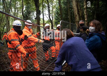 Cubbbington Woods, Warwickshire, Großbritannien. Oktober 2020. In den frühen Morgenstunden des 5. Okt. 2020 ergreifen friedliche HS2-Demonstranten Maßnahmen zum Schutz der Eichen und alten Wälder, die für die Zerstörung in Cubbbington Woods, Warwickshire, Großbritannien, markiert sind. Demonstranten erhalten Zugang zu dem Land, das HS2 erworben hat und Arme um Bäume verbindet, die mit Farbe gekennzeichnet sind Kredit: Denise Laura Baker/Alamy Live News Stockfoto