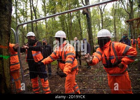 Cubbbington Woods, Warwickshire, Großbritannien. Oktober 2020. In den frühen Morgenstunden des 5. Okt. 2020 ergreifen friedliche HS2-Demonstranten Maßnahmen zum Schutz der Eichen und alten Wälder, die für die Zerstörung in Cubbbington Woods, Warwickshire, Großbritannien, markiert sind. Sie werden mit einer gewaltsamen Räumung durch die HS2-Sicherheit getroffen. Die Demonstranten sind dann geteilt und versuchen, den Eintritt in die Verbindung zurückzugewinnen.Kredit: Denise Laura Baker/Alamy Live News Stockfoto