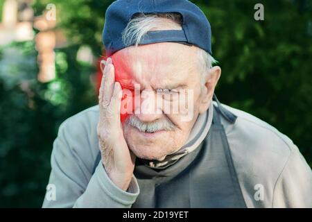 Ältere Menschen leidet unter Kopfschmerzen, Bluthochdruck, Stress oder Migräne. Kranke alte Mann leidet unter Kopfschmerzen, Migräne mit roten Akzent Angst Stockfoto