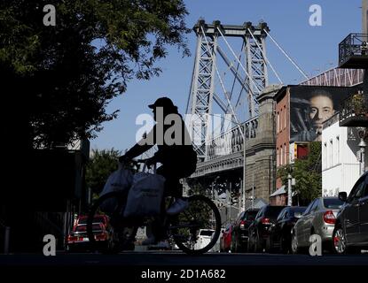 Williamsburg, Usa. Oktober 2020. Ein Radfahrer fährt am Montag, 5. Oktober 2020, an der Williamsburg Bridge in South Williamsburg in New York City vorbei. Bürgermeister Bill de Blasio kündigte seinen Plan an, Schulen und nicht-wesentliche Geschäfte wieder in neun Postleitzahlen in Brooklyn und Queens am Sonntag wegen einer Spitze in Coronavirus-Infektionen zu schließen. Foto von John Angelillo/UPI Kredit: UPI/Alamy Live Nachrichten Stockfoto