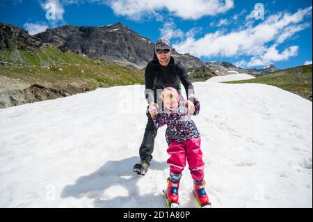 Glücklicher Vater lehrt seine Tochter Skifahren. Stockfoto