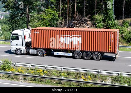 MAN TGX LKW mit HMM Container auf Autobahn. Stockfoto