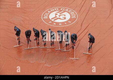 Paris, Frankreich. Oktober 2020. Tongärtner des Stadions Suzanne Lenglen werden während des Tennisturniers Roland Garros 2020, Grand Slam, am 5. Oktober 2020 im Roland Garros Stadion in Paris, Frankreich, das Wasser der Plane entfernt - Foto Stephane Allaman / DPPI Kredit: LM/DPPI/Stephane Allaman/Alamy Live News Stockfoto