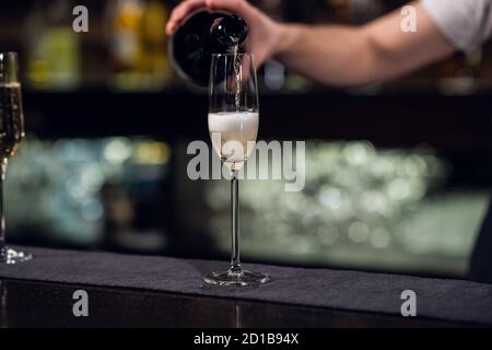 Nahaufnahme eines Glases Champagner aus einer Flasche. Stockfoto