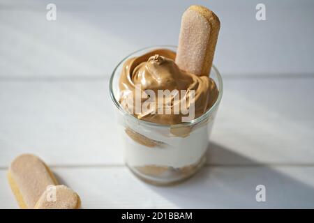 Iced schaumig Dalgona Coffee Tiramisu, ein trendiger flauschiger cremiger Schlagkaffee auf der Oberseite des Tiramisu Dessert. Koreanische trinken Latte Espresso mit Kaffee Schaum. Savoyardi oder ladyfinger Dessert. Stockfoto