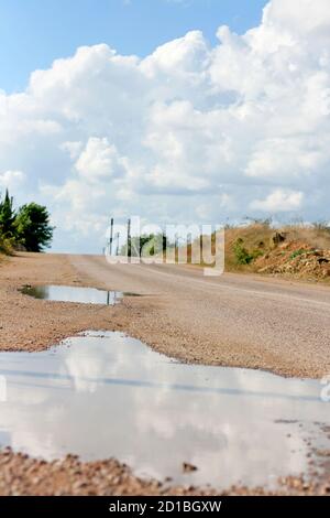 Pfützen die nächste nach dem Regen in den Gruben auf der Straße. Klares Wetter. Stockfoto