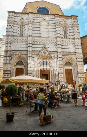 façade des Baptisteriums von St. John in der Altstadt von Siena, UNESCO-Weltkulturerbe, mit Menschen und Touristen im Sommer, Toskana, Italien Stockfoto