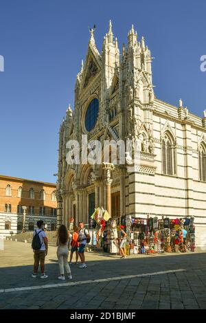 Außenansicht der Kathedrale von Siena (13. jh.) im romanisch-gotischen Stil, UNESCO-Weltkulturerbe, mit Souvenirständen und Touristen, Toskana, Italien Stockfoto