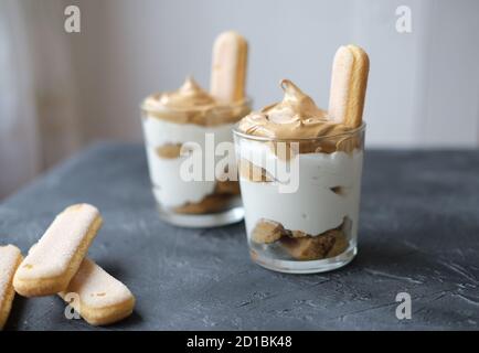 Iced schaumig Dalgona Kaffee Tiramisu in einem Glas, eine trendige flauschige cremige Schlagkaffee auf der Oberseite des Tiramisu Dessert. Koreanische trinken Latte Espresso mit Kaffee-Schaum. Stockfoto