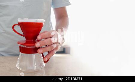 Set für die Herstellung von V60 auf dem Tisch. Männer Hand hält Glas Server. Pourover Stockfoto