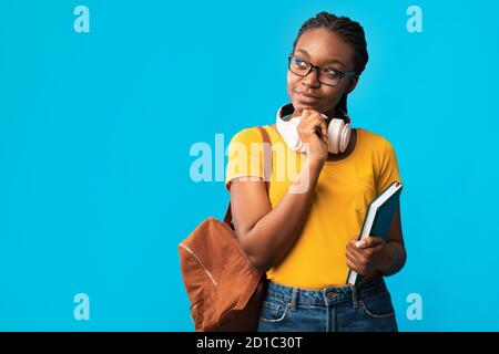 Nachdenklich Afrikanisch Frau Student Thinking Holding Bücher Auf Blauem Hintergrund Stockfoto