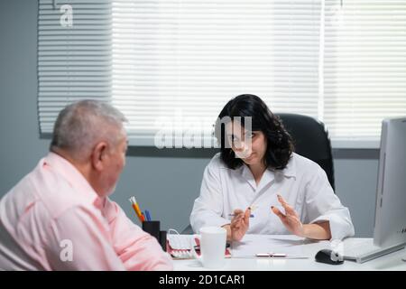 Ärztin versucht, ihre ältere Patientin zu beruhigen in einem Krankenhaus sagt sie ihm, dass alles Schon gut. sein wird Stockfoto