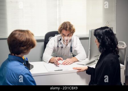 Ein junges Paar, das eine Konsultation mit einem Arzt in einem Krankenhaus hat. Stockfoto