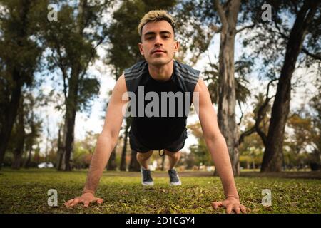Kaukasischer Mann, der Liegestütze im Park macht Stockfoto