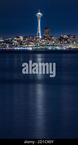 Die kultige Space Needle und Elliot Bay in Seattle, Washington, bei Nacht, vom Alki Beach Stockfoto